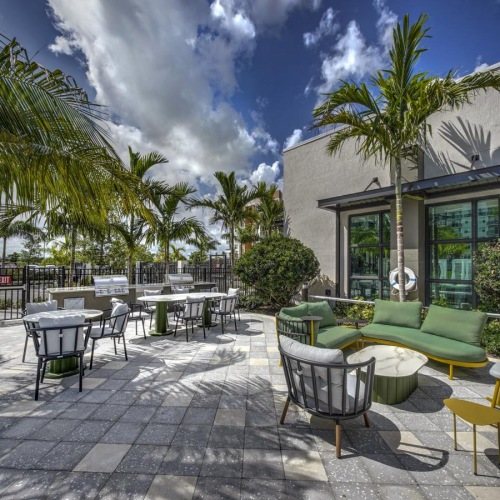 Settle into comfort at The Pomelo a patio with tables and chairs and trees