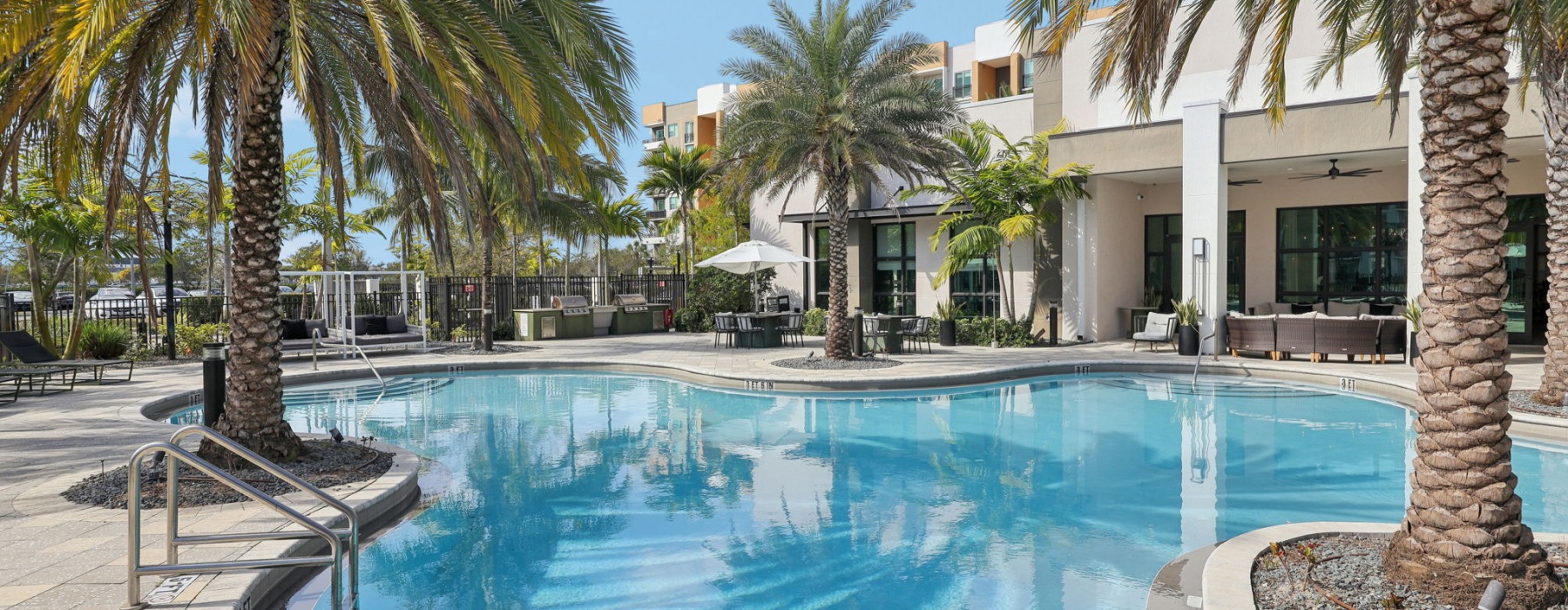 Outdoor pool with blue water and palm trees