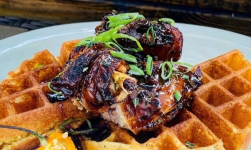 Plate of waffles with food on top