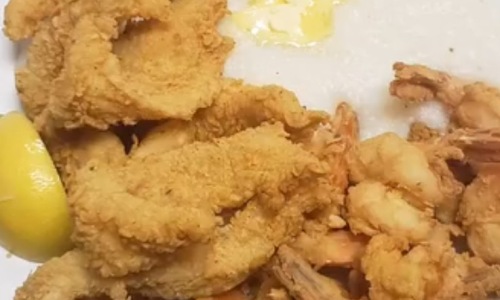 Plate of fried food in grits with lemons