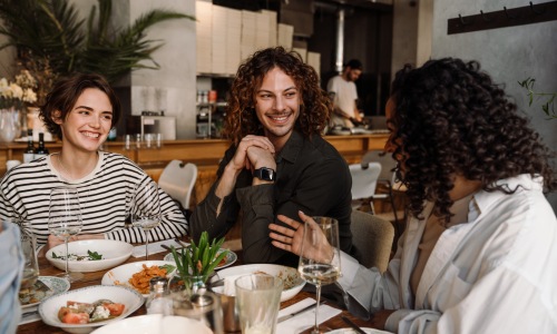 Restaurants near The Pomelo Apartments Miami Gardens Group of friends around a table laughing