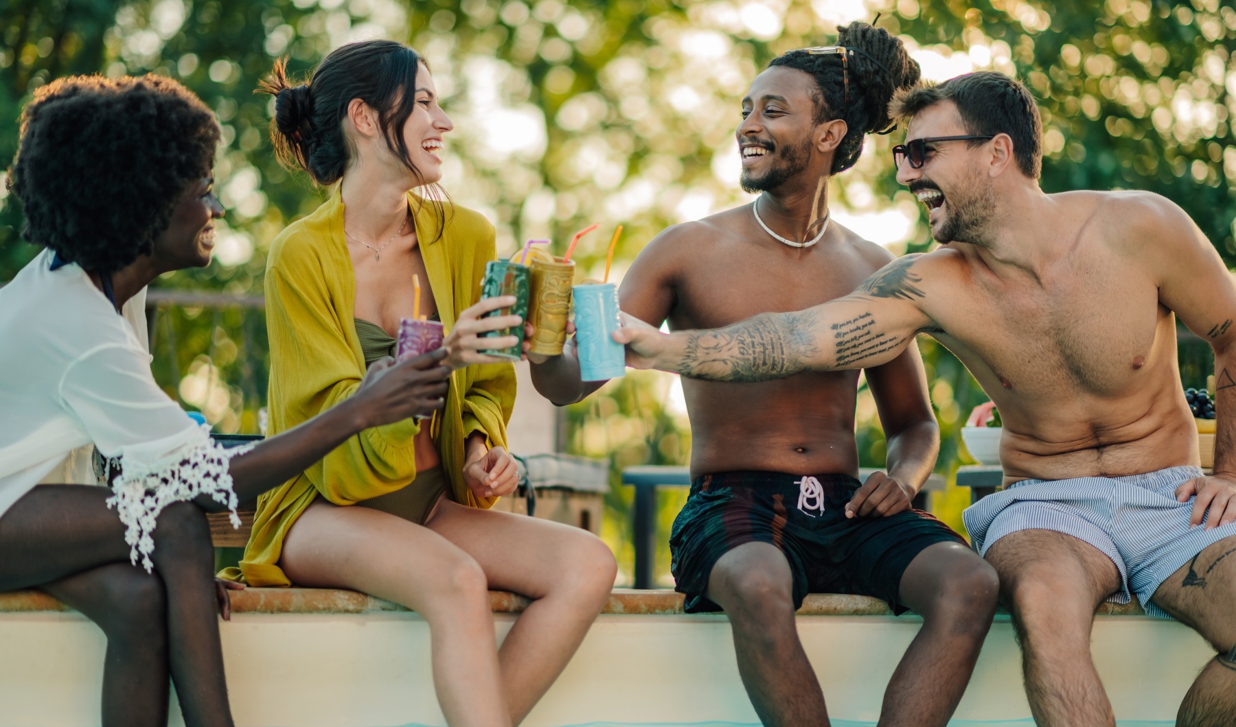 Group of friends having drinks by the pool